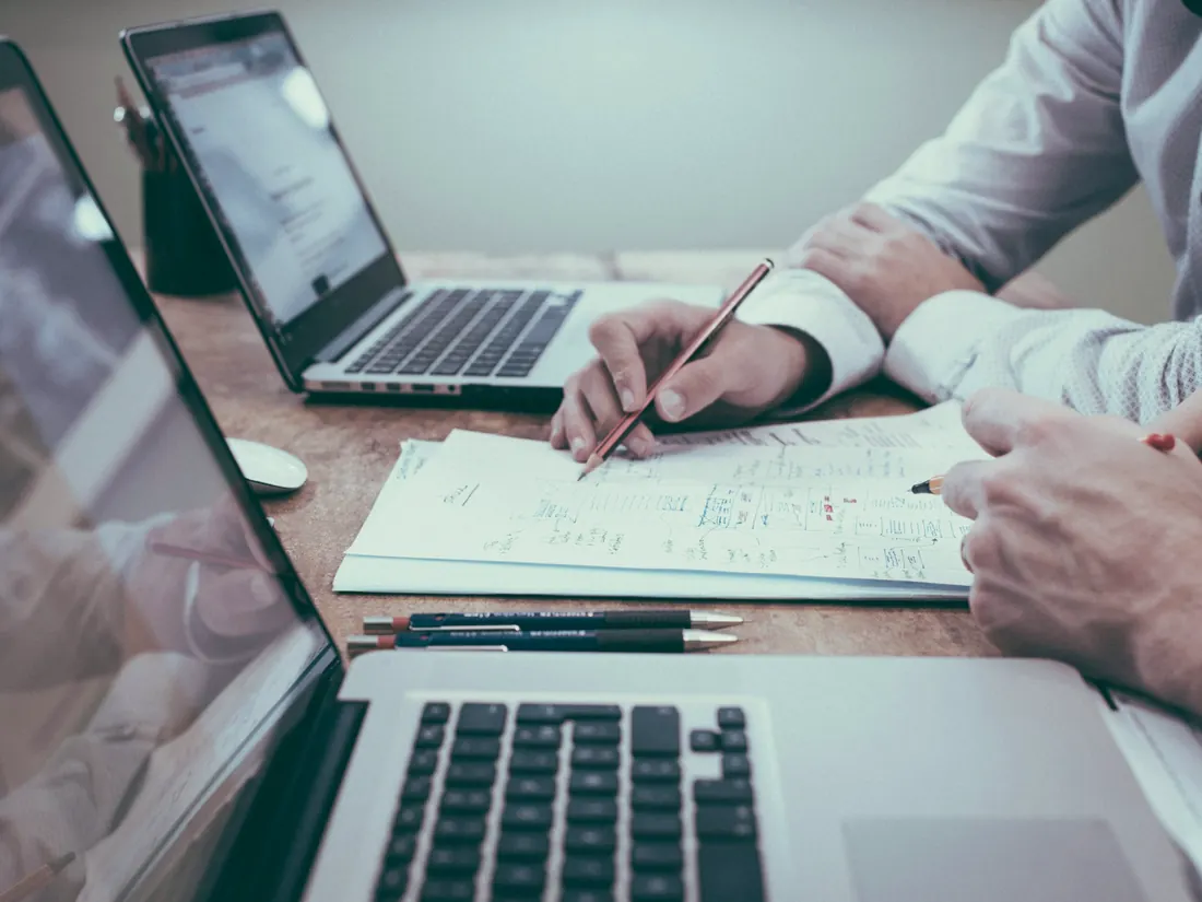 Notas de trabajo y portátiles sobre una mesa de reunión