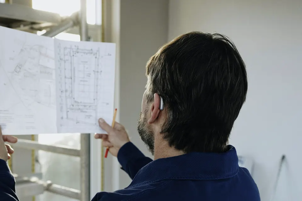 Profesional revisando planos en una obra